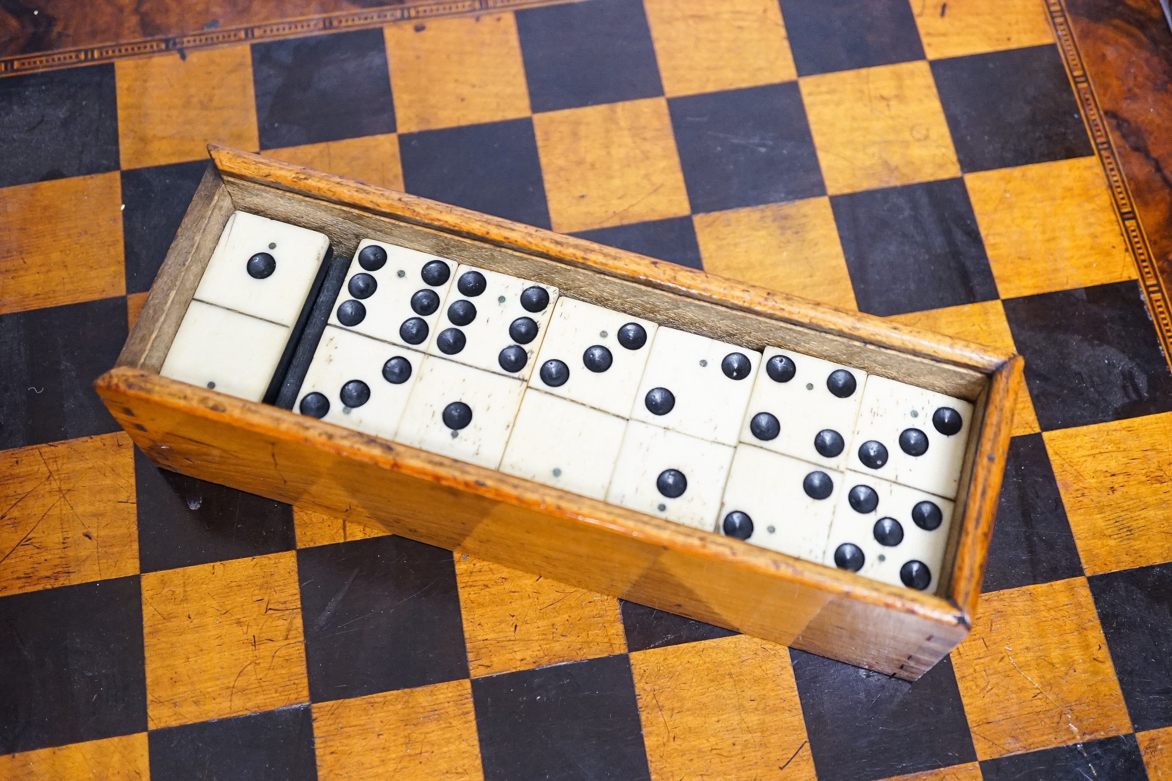 A late 19th century walnut, ebony and sycamore chessboard together with a box set of dominoes, chessboard 41cm x41cm